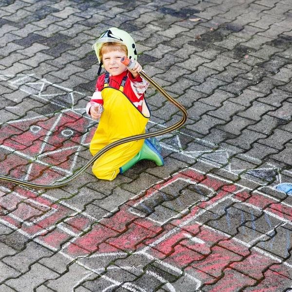 Смешной маленький ребенок четырех лет веселится с пожарной машиной пикта — стоковое фото