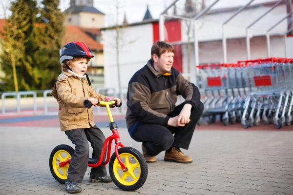 Copil mic cu bicicleta si tatal sau in oras — Fotografie, imagine de stoc