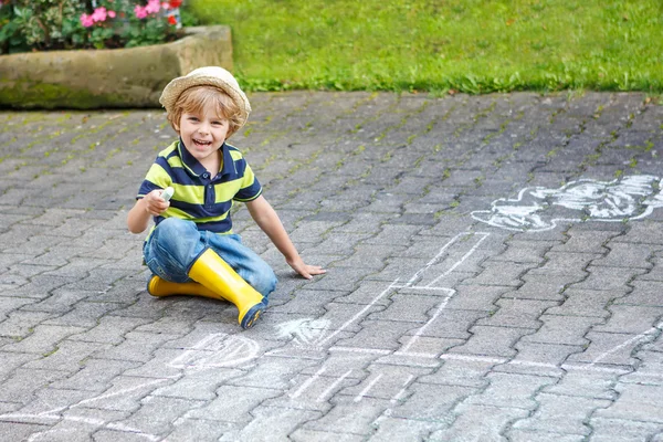 Little boy painting a tractor vehicle with chalk in summer — Stock Photo, Image