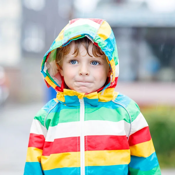Kleiner blonder Junge geht mit großem Regenschirm im Freien — Stockfoto