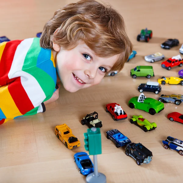 Adorable cute child with lot of different colorful toy cars — Stock Photo, Image