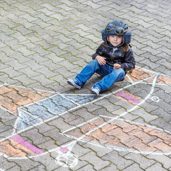 Niño divirtiéndose con el dibujo de la imagen del avión con tiza —  Fotos de Stock