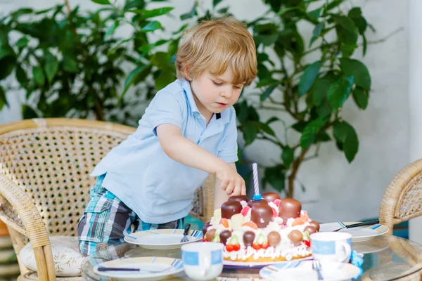 Little boy celebrating his birthday in home's garden with big ca — Stock Photo, Image