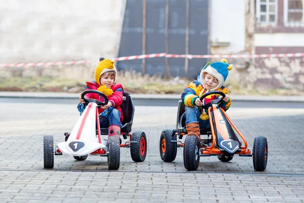 Dos niños pequeños que se divierten con coches de carreras de juguete — Foto de Stock