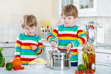 İki küçük çocuklar yerli mutfakta spagetti yiyen çocuk.
