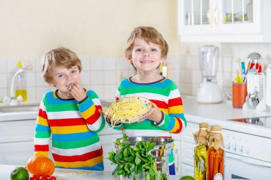 İki küçük çocuklar yerli mutfakta spagetti yiyen çocuk.