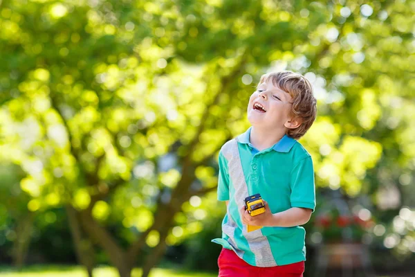 Menino brincando com brinquedo de carro, ao ar livre — Fotografia de Stock