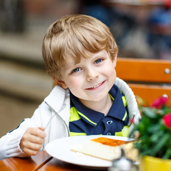 Little kid boy, laughing and eating cake in outside cafe — Stock Photo, Image