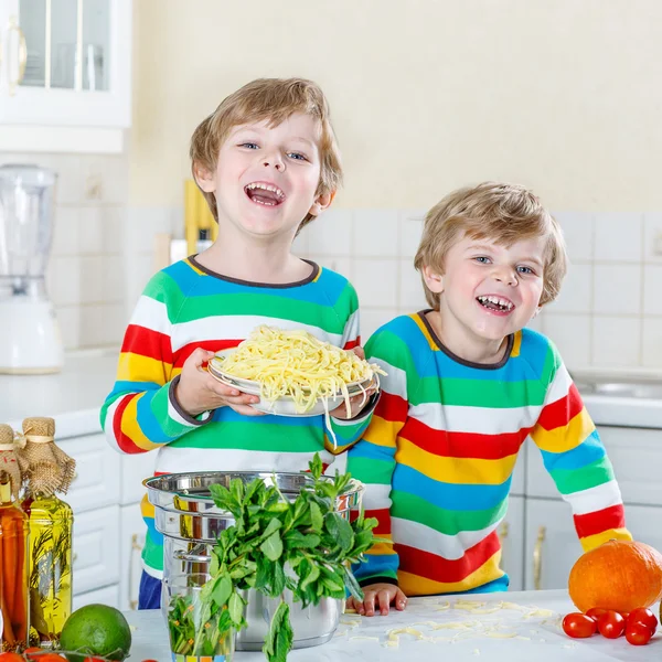 Két kis gyerek fiú eszik spagetti hazai konyha. — Stock Fotó