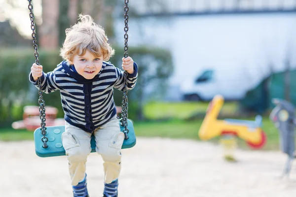 愛らしい幼児男の子楽しんで屋外 playgroun でスイングのチェーン — ストック写真