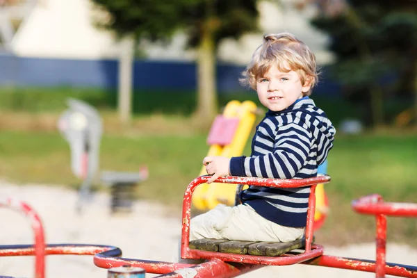 Kleine peuter jongen plezier op oude carrousel op buiten playgro — Stockfoto