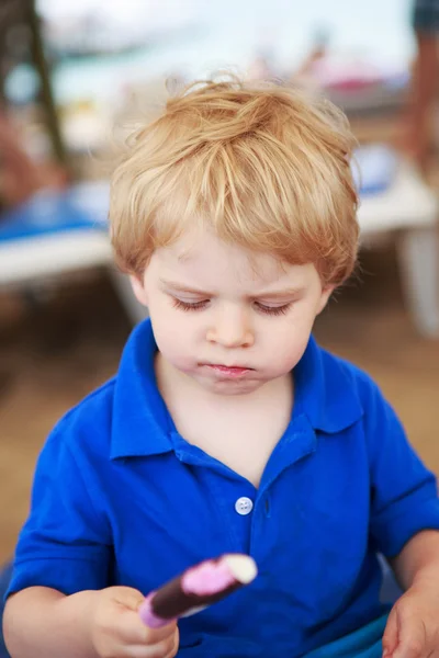 Little blond toddler eating chocolate ice cream — Stock Photo, Image