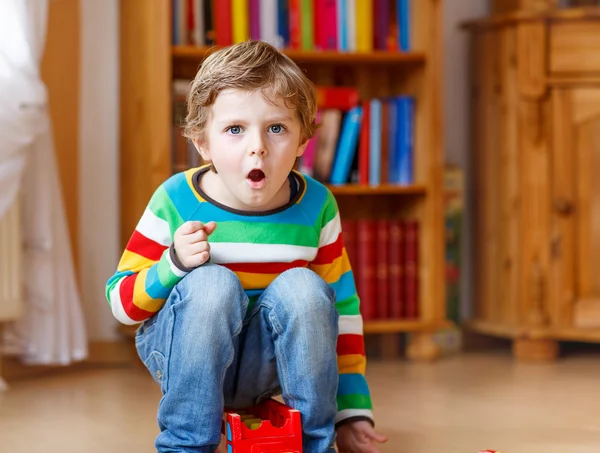 Divertente ragazzo biondo urlando e giocando, in casa — Foto Stock
