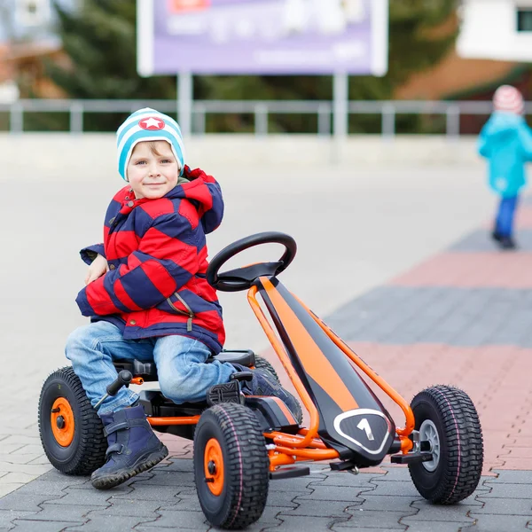 おもちゃのレース車を楽しんでは活発なかわいい男の子 — ストック写真
