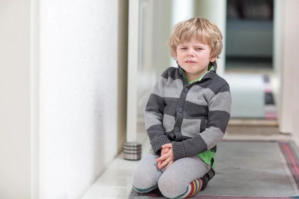 Μικρό παιδί αγόρι κλαίει στο σπίτι και δείχνει θλιβερή διάθεση — Φωτογραφία Αρχείου