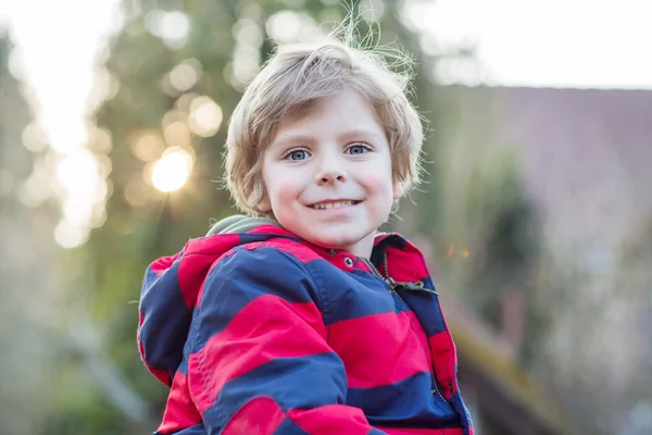 Portrait of happy little kid boy in red jacket, outdoors — Stock Photo, Image