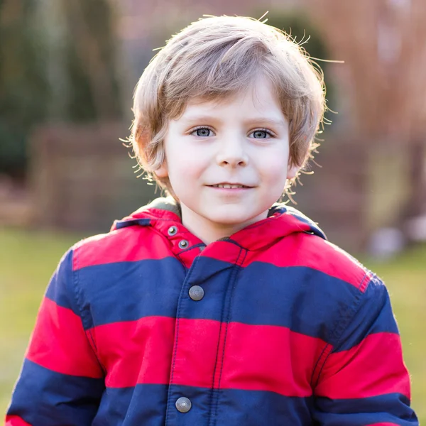 Retrato de niño feliz niño en chaqueta roja, al aire libre — Foto de Stock