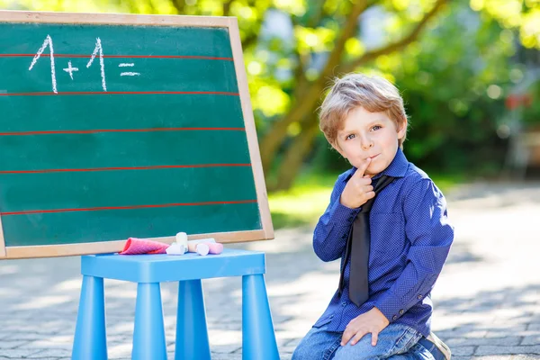 Little boy at blackboard learning to write — Stock Photo, Image