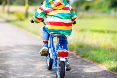 Little child in colorful clothes on bicycle