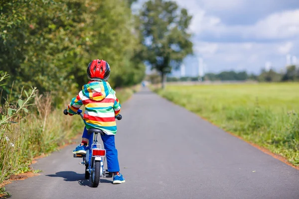 Kid jongen in helm met zijn eerste fiets, buitenshuis — Stockfoto