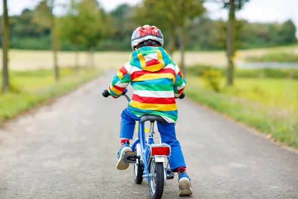 Active kid boy in safety helmet and colorful clothes on bike — ストック写真