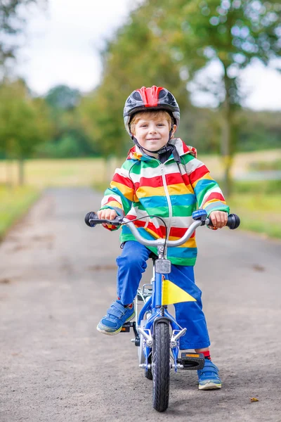 Happy adorable kid boy in safety helmet on bike — Stock Photo, Image