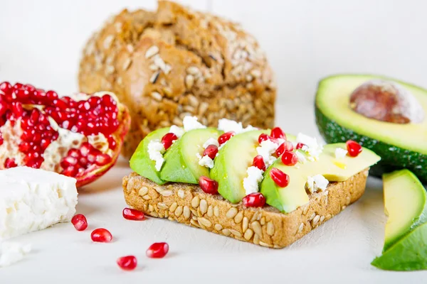 Avocado met Feta, granaatappel op zonnebloempitten brood broodje — Stockfoto