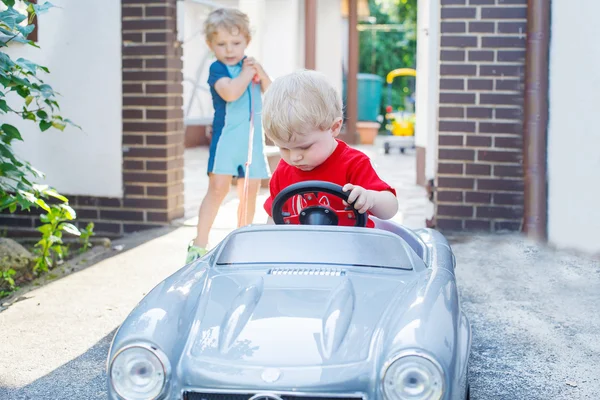 Dos hermanos pequeños jugando con coches —  Fotos de Stock