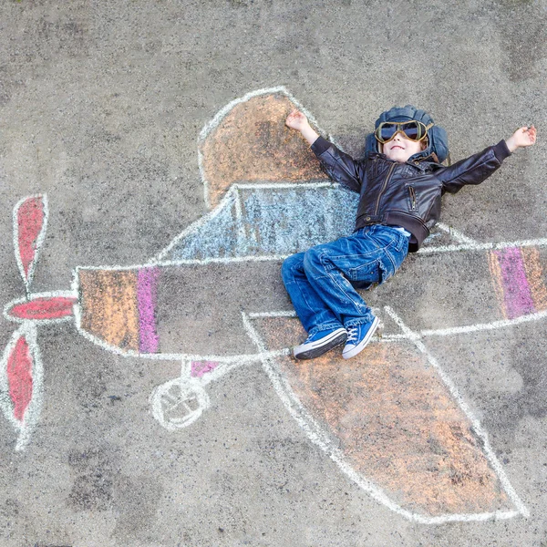 Kleine jongen plezier met vliegtuig afbeelding tekenen met krijt — Stockfoto