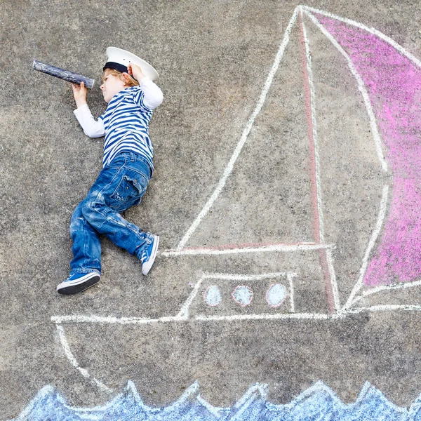 Beetje kid jongen met plezier met schip afbeelding tekenen met krijt — Stockfoto