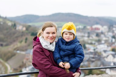  little child and young mother enjoying view city from above