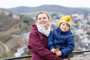  little child and young mother enjoying view city from above