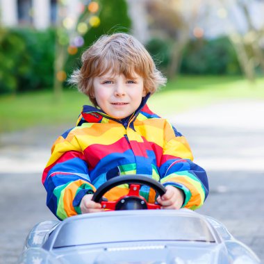 Küçük okul öncesi çocuk açık havada büyük oyuncak eski eski model araba, Araba sürme