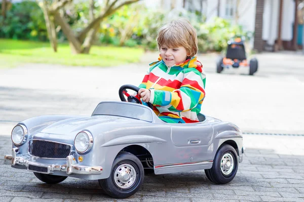 Deux garçons heureux frères et sœurs jouant avec une grande vieille voiture jouet — Photo