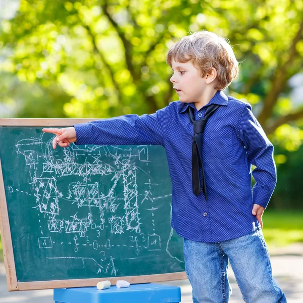 Liten pojke på blackboard lära sig att skriva — Stockfoto