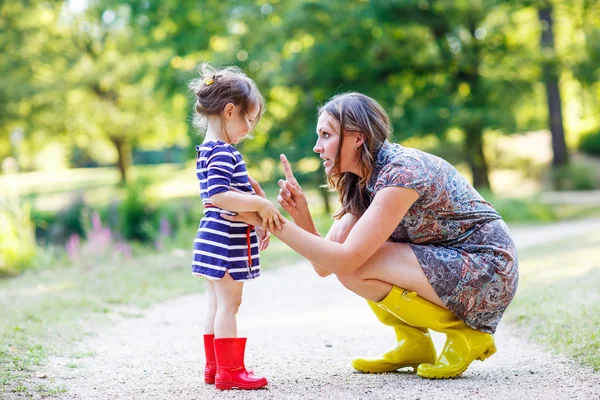 Mother and little adorable child in yellow rubber boots — Stock Photo, Image