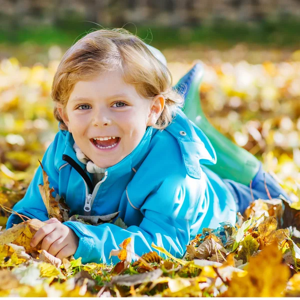 Kleiner Junge mit gelben Herbstblättern im Park — Stockfoto