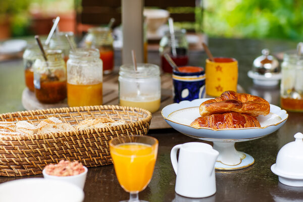 Стол накрыт на завтрак с различными вареньем кофе, круа
