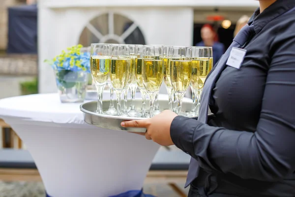 女服务员与盘的香槟和葡萄酒的眼镜 — 图库照片