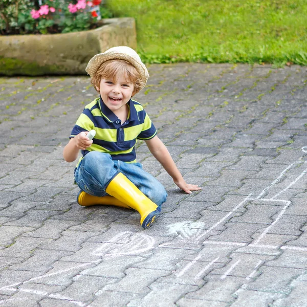 Little boy painting a tractor vehicle with chalk in summer — Stock Photo, Image