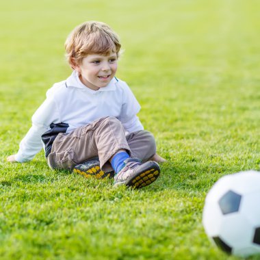 Futbol ve futbol sahasında oynayan iki küçük kardeş erkek