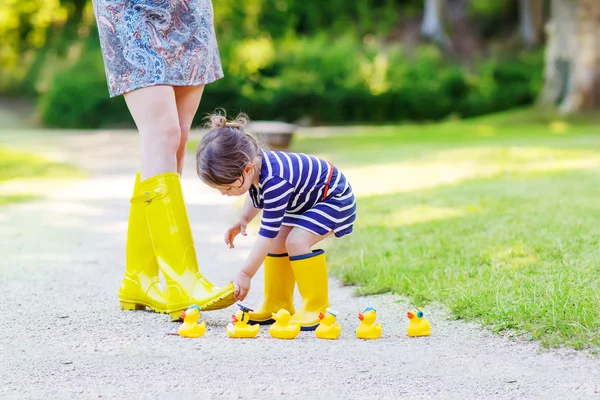 Mutter und kleines entzückendes Kind in gelben Gummistiefeln — Stockfoto