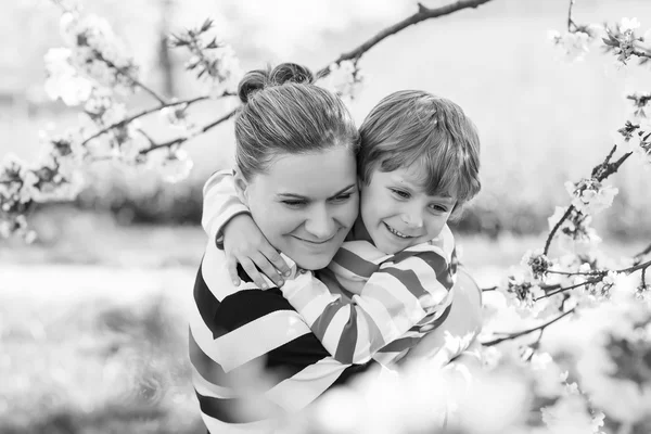Jeune mère et petit garçon s'amusent dans le jardin fleuri — Photo