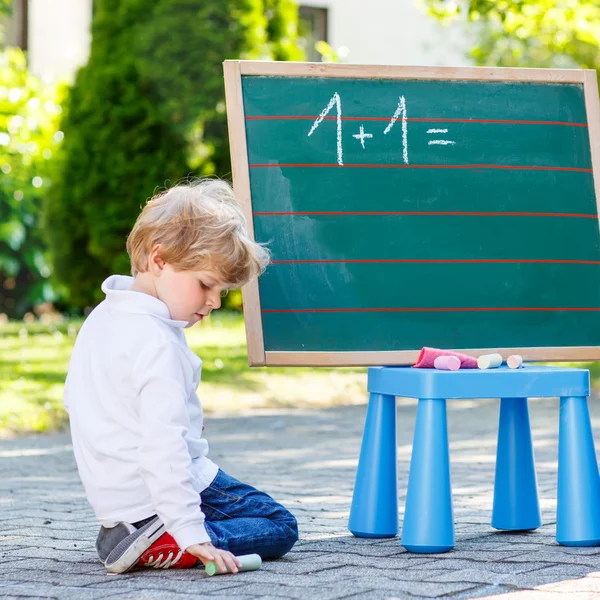 Dois meninos siblinig no quadro-negro praticando matemática — Fotografia de Stock