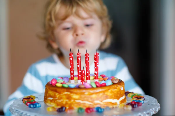 Kid boy celebrating his birthday and blowing candles on cake — Stock Photo, Image