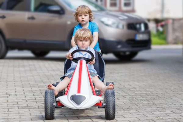 Dois felizes meninos amigos se divertindo com carro de brinquedo — Fotografia de Stock