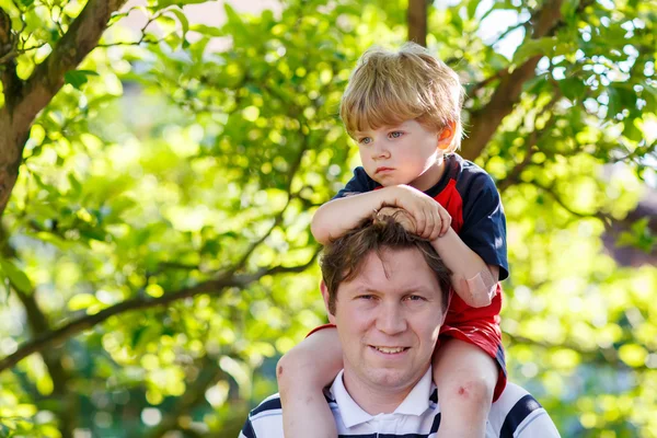 Pappa bär barnet på sina axlar i parken — Stockfoto