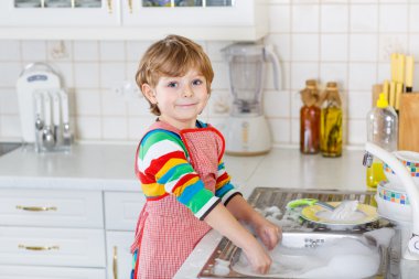 Mutlu küçük sarışın çocuk çocuk aile içi mutfakta bulaşık