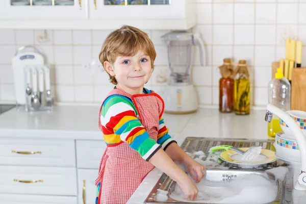 快乐小金发孩子男孩在国内厨房里洗盘子 — 图库照片