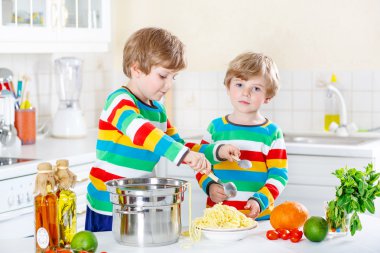 İki küçük çocuklar yerli mutfakta spagetti yiyen çocuk.
